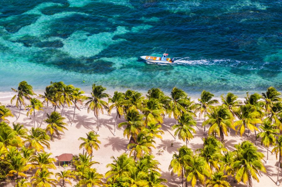 France, Petites Antilles, Guadeloupe, &icirc;le de La D&eacute;sirade, un bateau de p&ecirc;che longe la plage su Souffleur dans le lagon, vu depuis le plateau sommital // France, French West Indies, Guadeloupe, island of La D&eacute;sirade, a fishing boat along Souffleur beach in the lagoon, seen from the summit plateau