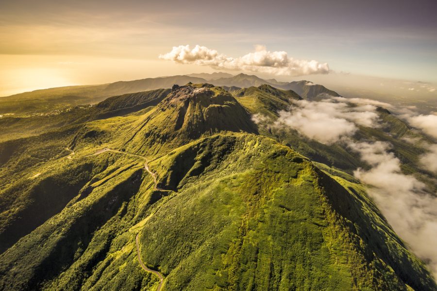 France, Guadeloupe, Basse-Terre, Saint-Claude, Vue a&eacute;rienne Sud-Nord du sommet d&eacute;gag&eacute; de la Soufri&egrave;re, l'&Eacute;chelle et toute la cha&icirc;ne volcanique, visibles ensemble quelques jours par an seulement, ici en surplomb de La Citerne. Surnomm&eacute;e &laquo; vi&eacute; madanm la &raquo; en cr&eacute;ole guadeloup&eacute;en ou &laquo; la vieille dame &raquo; en fran&ccedil;ais, est un volcan en activit&eacute; situ&eacute; dans le parc national. Seul volcan actif de l&rsquo;&icirc;le, actuellement &agrave; l&rsquo;&eacute;tat de repos &eacute;ruptif, elle fait partie d&rsquo;un ensemble volcanique compos&eacute; des volcans Carmicha&euml;l, le Nez Cass&eacute;, l&rsquo;&Eacute;chelle, la Citerne et la Madeleine. C'est l&rsquo;un des neuf volcans actifs des Petites Antilles. La v&eacute;g&eacute;tation sur les flancs de la Soufri&egrave;re est remarquable pour sa biodiversit&eacute;. Elle s'&eacute;tage sur trois niveaux : la for&ecirc;t tropicale dense jusqu'&agrave; 1 100 m&egrave;tres, les maquis humides denses entre 1 100 et 1 400 m&egrave;tres compos&eacute;s d'arbustes ne d&eacute;passant pas deux m&egrave;tres de hauteur (entre autres, Schefflera attenuata, Clusia mangle, Miconia coriacea), les prairies sommitales d'o&ugrave; &eacute;mergent des bromeliaceae : Guzmania plumieri omnipr&eacute;sent, et surtout Pitcairnia bifrons, esp&egrave;ce pionni&egrave;re pr&eacute;sente jusqu'au bord des bouches &eacute;ruptives (PR) // France, Guadeloupe, Basse-Terre, Saint-Claude, Aerial View South-North summit free of La Soufri&egrave;re, L'&Eacute;chelle and all the volcanic chain, visible together only a few days a year, here overlooking La Citerne. Nicknamed "the vi&eacute; madanm" in Guadeloupean Creole or "the old lady" in French, La Soufri&egrave;re is an active volcano located in the national park. Only active volcano on the island, currently the eruptive resting state, it is part of a volcanic ensemble of Carmichael volcanoes, Nose Broken, Scale, Cistern and the Madeleine. This is one of the nine active volcanoes of the Lesser Antilles. The vegetation on the slopes of La Soufri&egrave;re is noted for its biodiversity. It sprawls over three levels: the dense tropical forest to 1100 meters, dense humid scrub between 1100 and 1400 m